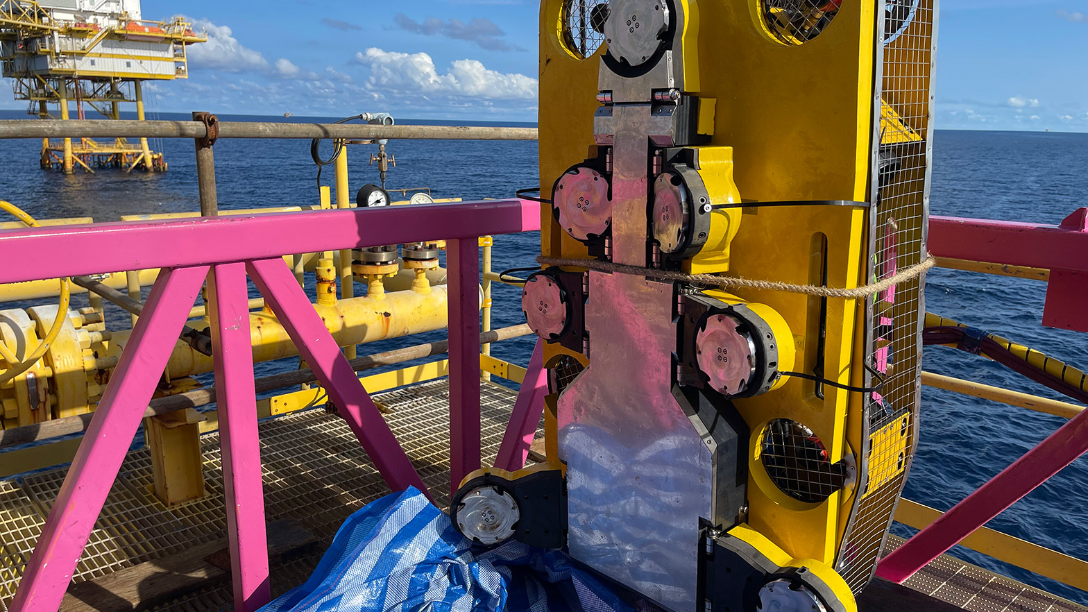 Workers place the mini ROV in a metal basket before submerging it.