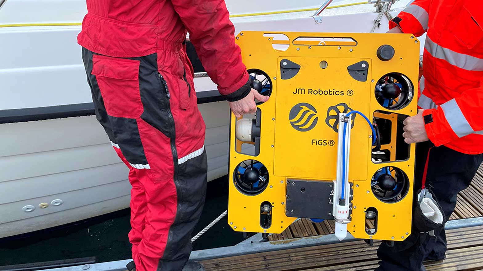 two workers carry a ROV to the water